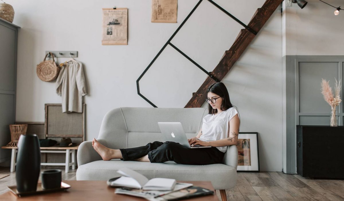 content young woman using laptop in modern living room